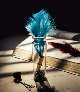 feather in glass bottle on table