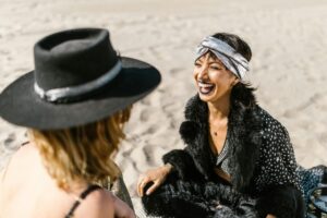 two women sitting on the beach